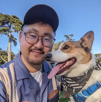 Tae and his corgi, Gamja, taking a break while walking on a sunny day.